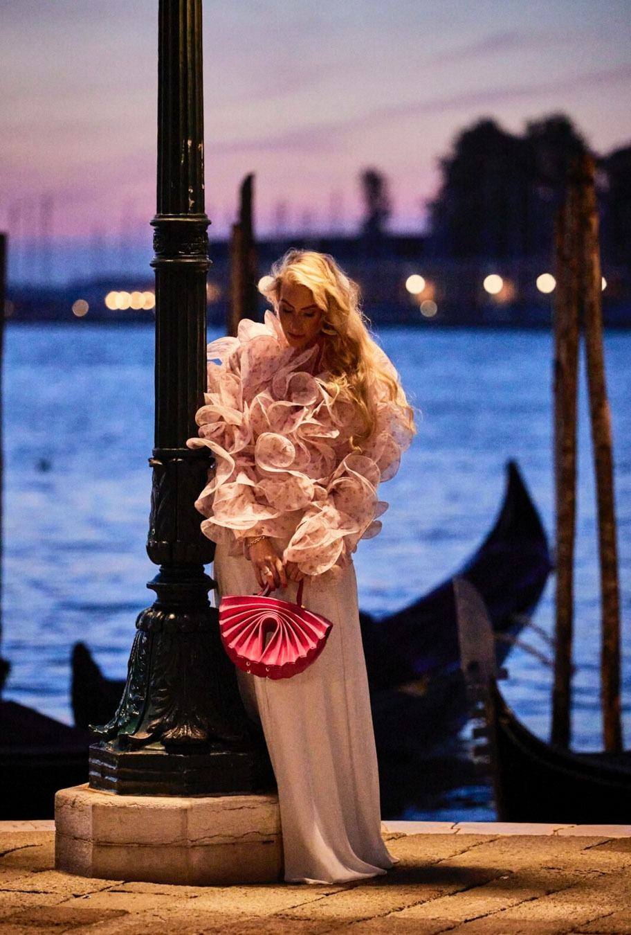 Juliane Golbs am Abend an der Lagune in Venedig, im Hintergrund Gondeln und die Lichter der Stadt