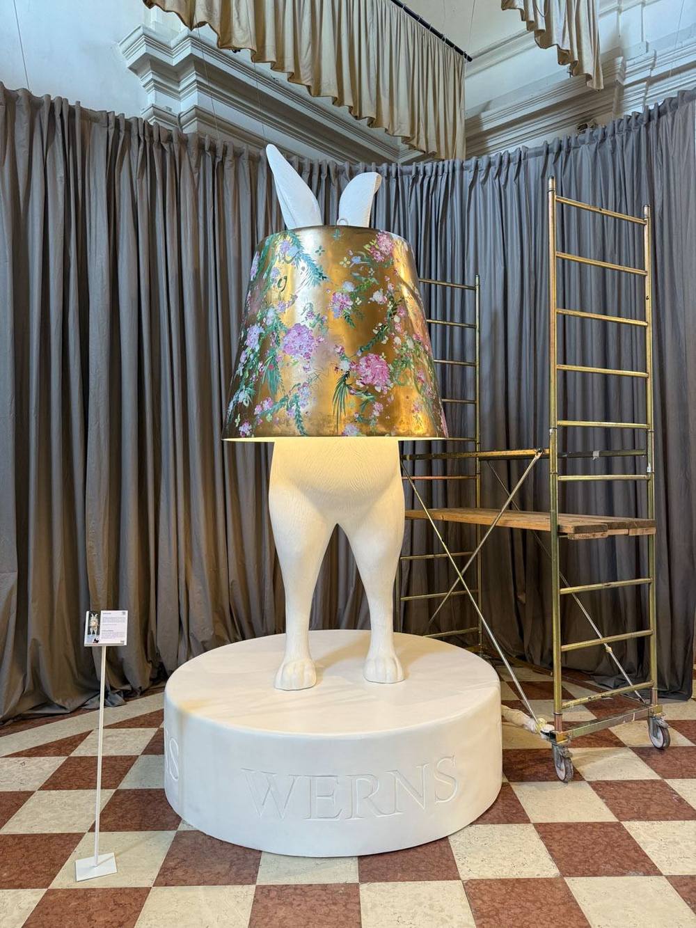 Die von Juliane Golbs bemalte Hasenskulptur von WERNS mit goldenem, floral bemaltem Schirm in der Kirche San Leonardo in Venedig
